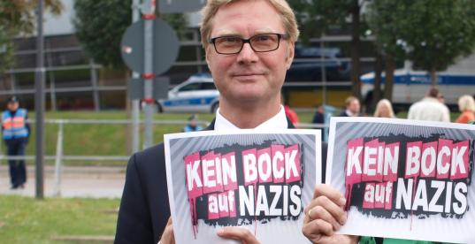 Dirk Adams hält ein Plakat mit der Aufschrift: "Kein Bock auf Nazis"