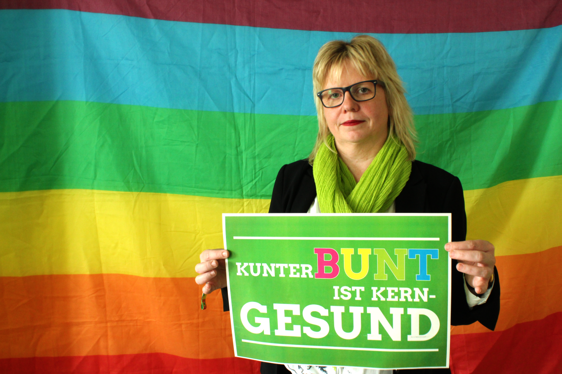 Babett Pfefferlein vor Regenbogenflagge