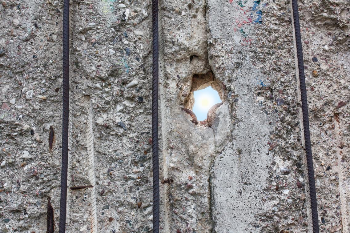 Ein Lichtstrahl fällt durch ein Loch in der Berliner Mauer