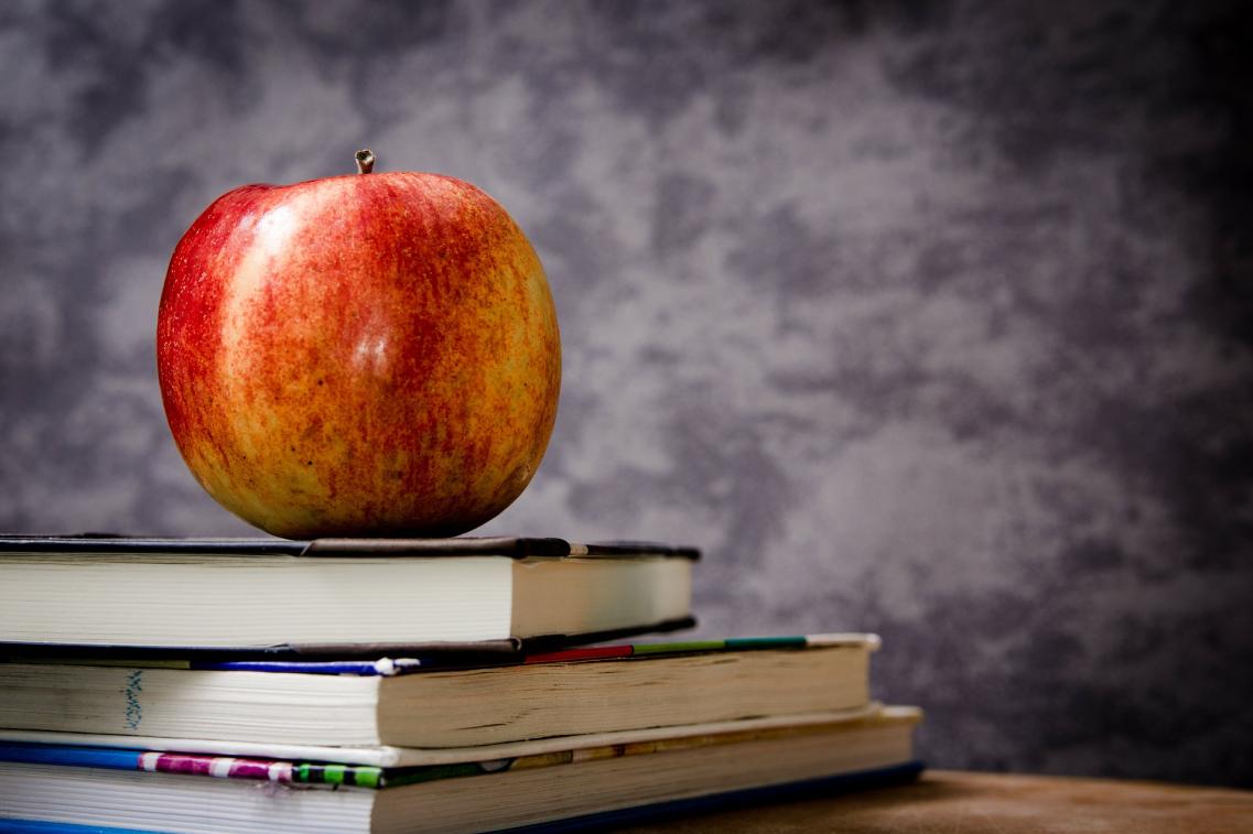 Ein Apfel liegt auf Schulbüchern 