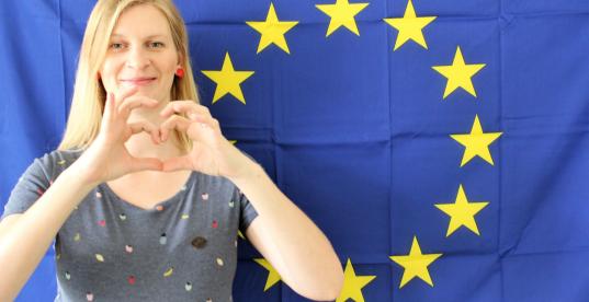 Madeleine Henfling zeigt Herz mit Händen vor Europaflagge