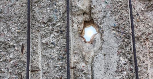 Ein Lichtstrahl fällt durch ein Loch in der Berliner Mauer