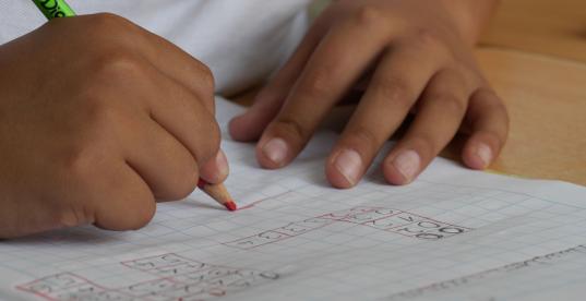 Ein Kind im Grundschulalter lernt Schreiben 